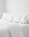 White textured pillow on a bed with a neutral background